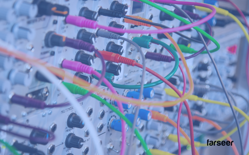 Complex web of colorful cables plugged into hardware – representing the tangled integrations companies face when choosing to Build vs Buy Software.
