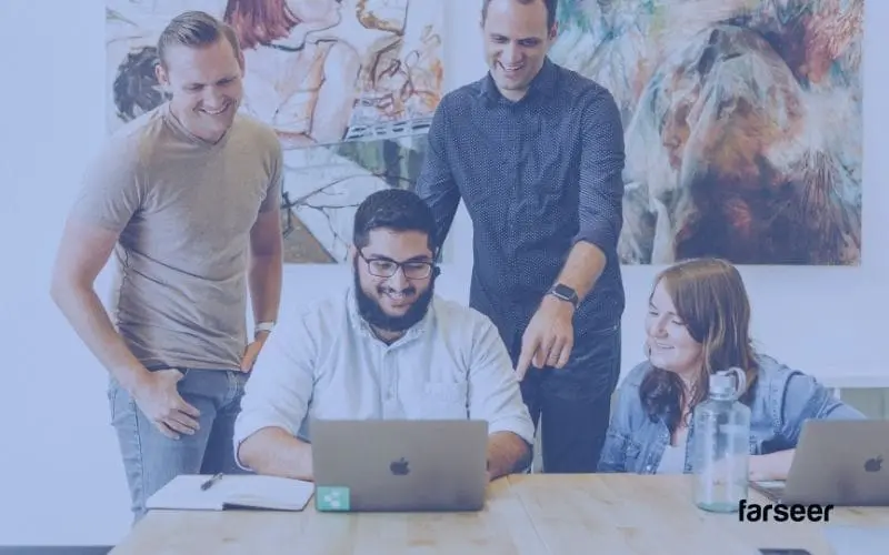 Finance team collaborating over a laptop – showcasing how buying software can speed up collaboration showing pigment competitors