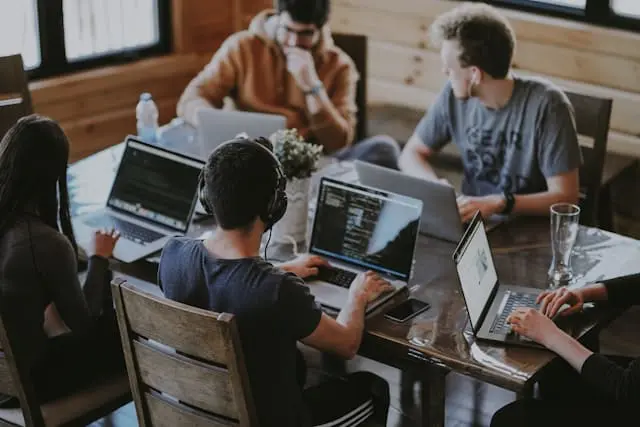 employees working on their computers around a table