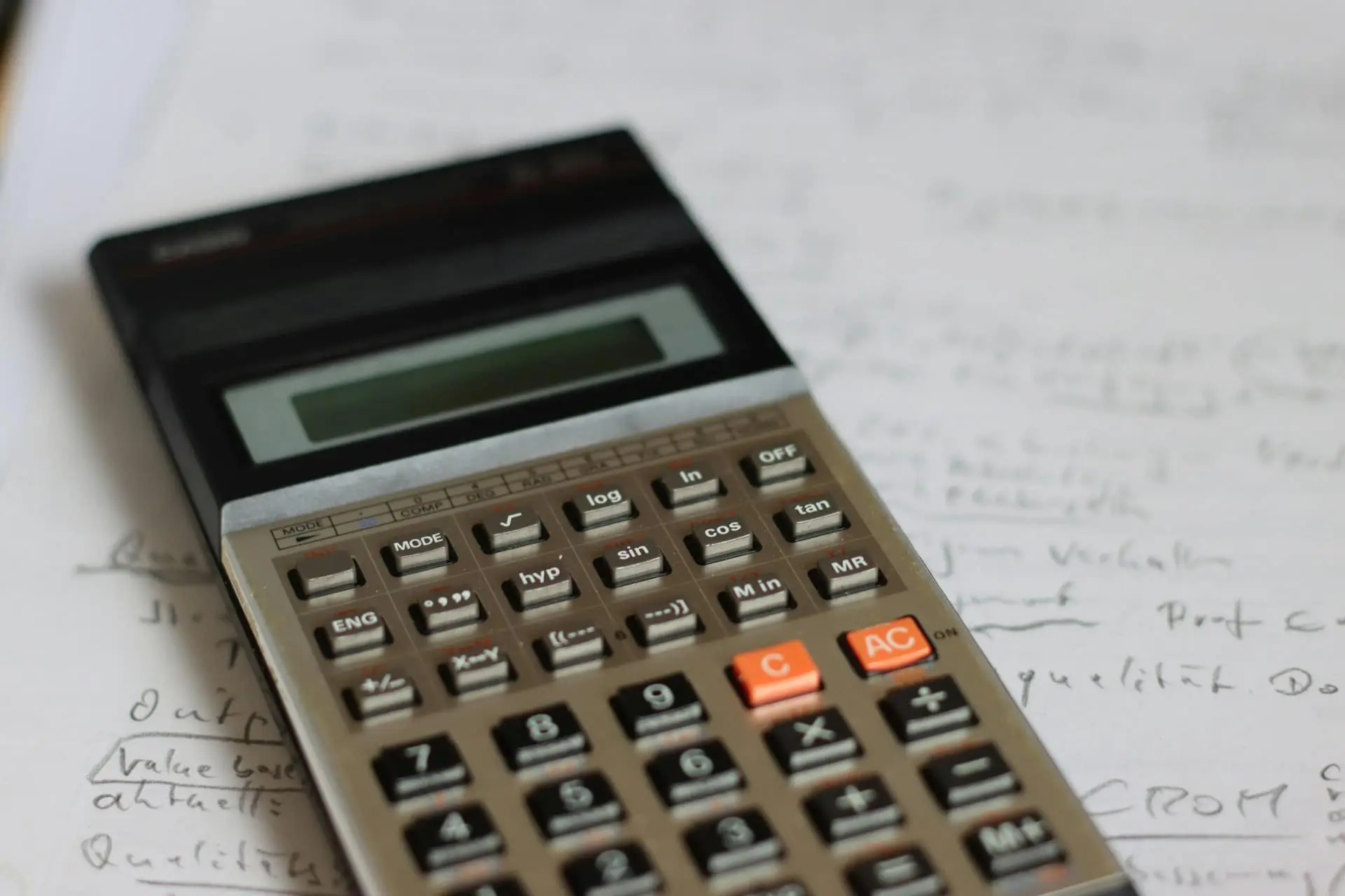Close-up of a scientific calculator resting on handwritten notes, representing financial calculations, analysis, or ratio computation
