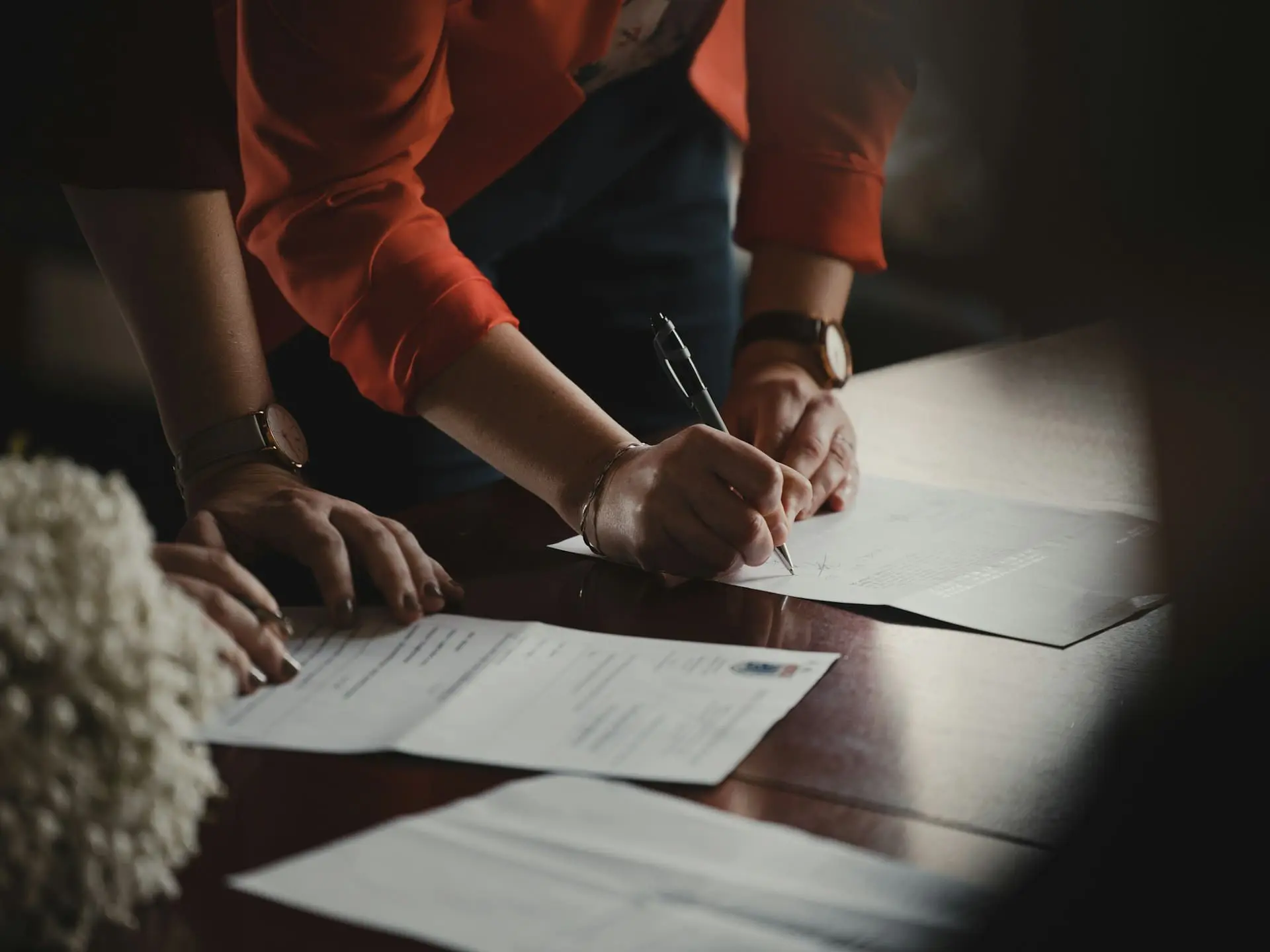 people standing around a table working on paperwork