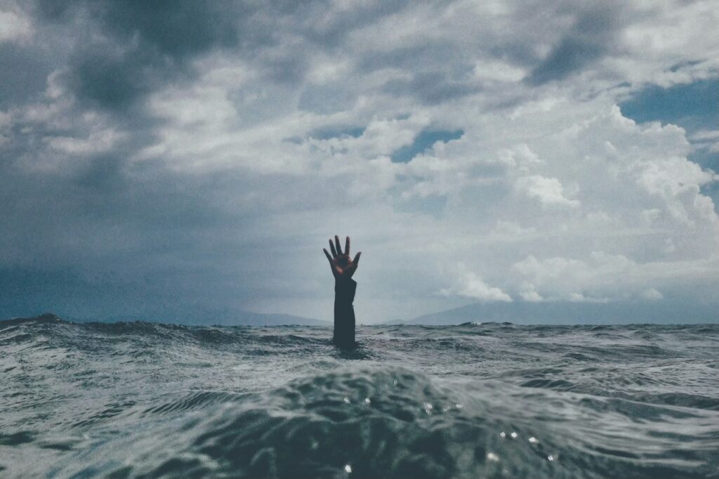hand in the middle of ocean symbolising struggle of not having right enterprise planning software