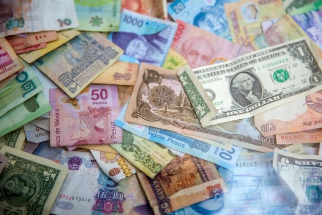different currency bills piled on top of each other