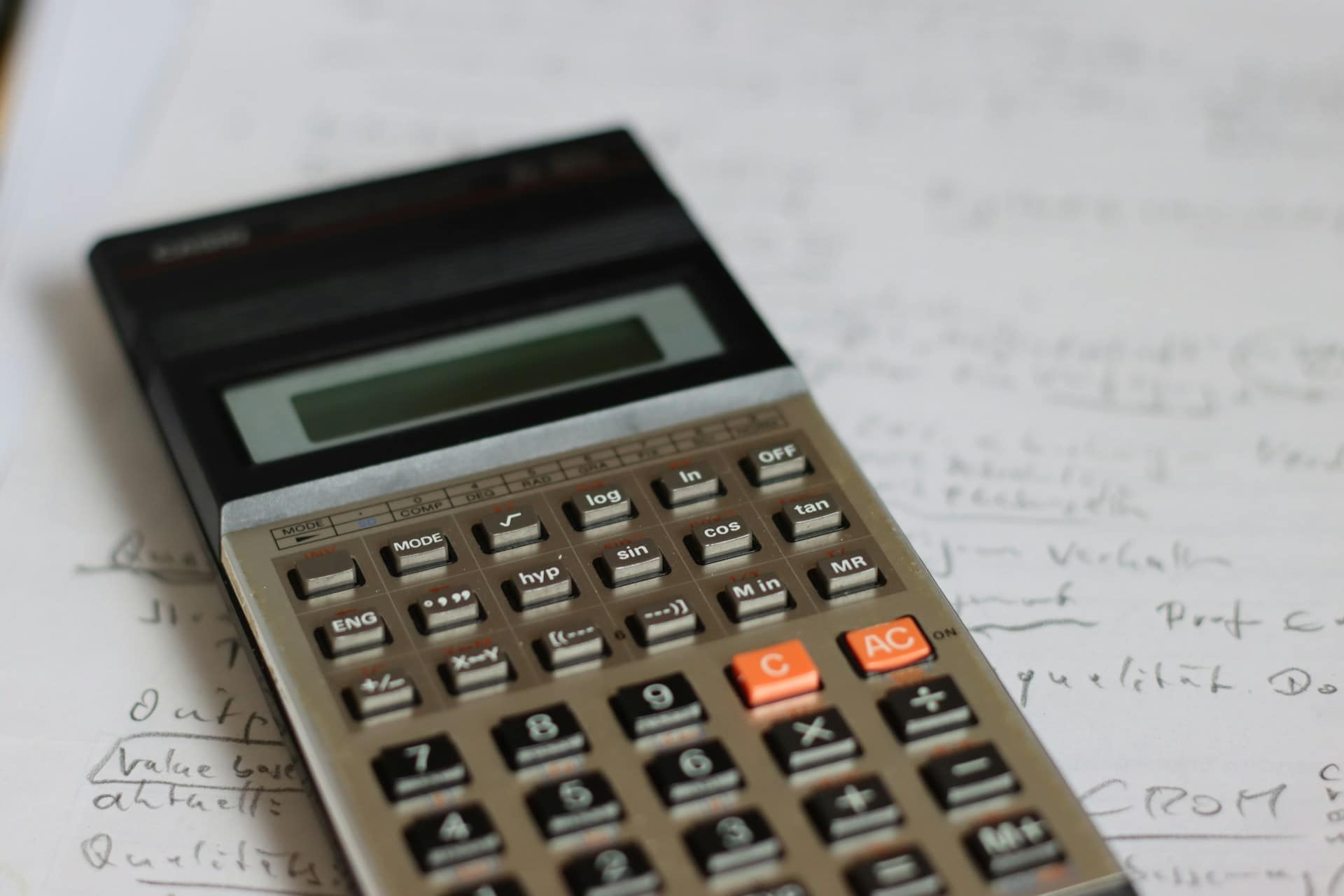 Close-up of a scientific calculator resting on handwritten notes, representing financial calculations, analysis, or ratio computation