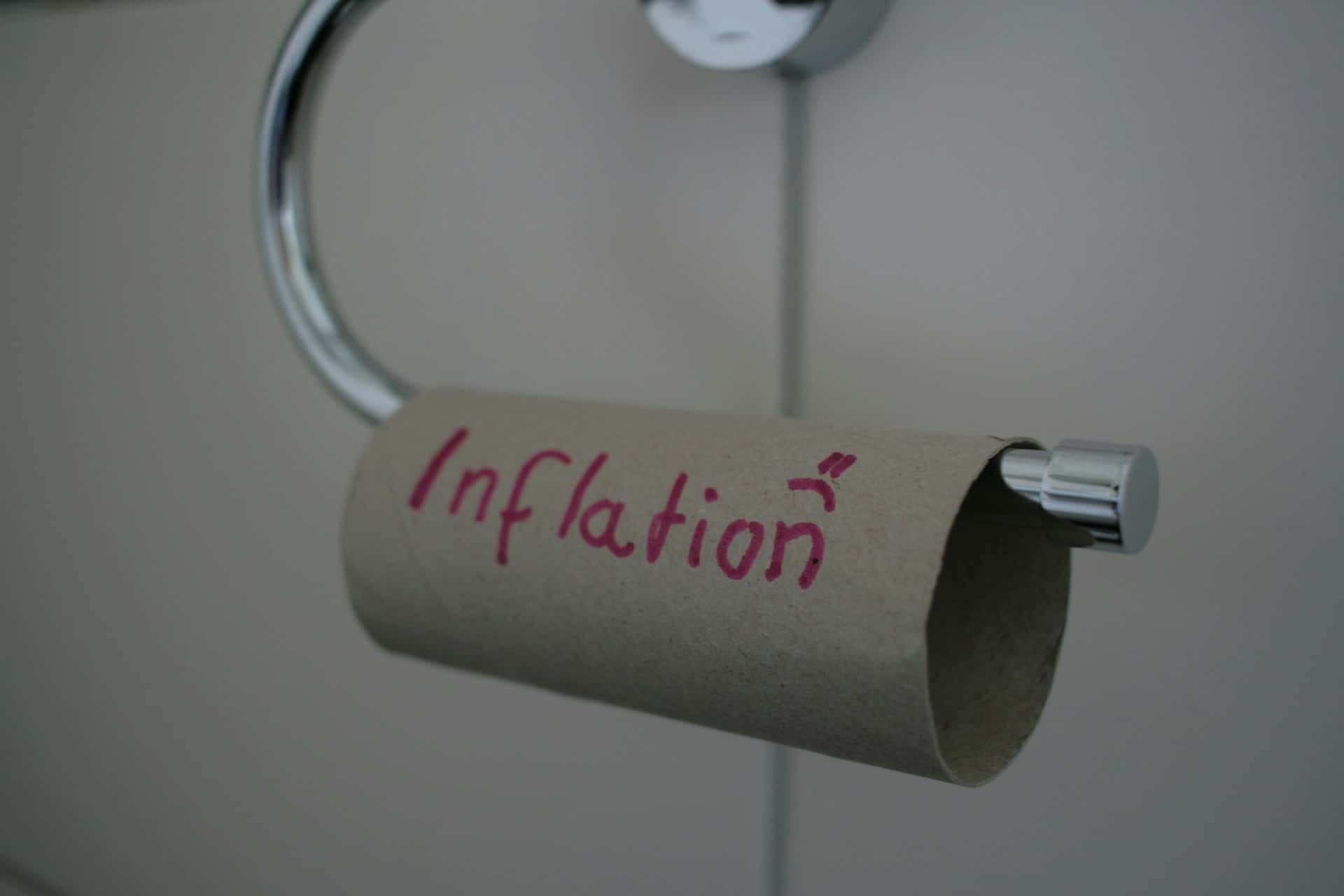 Empty toilet paper roll labeled "Inflation" in red marker, mounted on a silver holder, symbolizing economic shortage or rising prices.