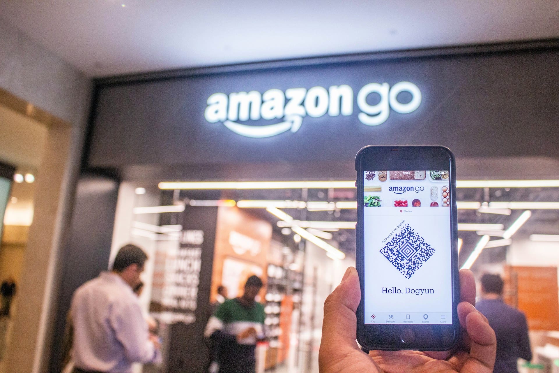 a phone showing a QR code and amazon store behind it 